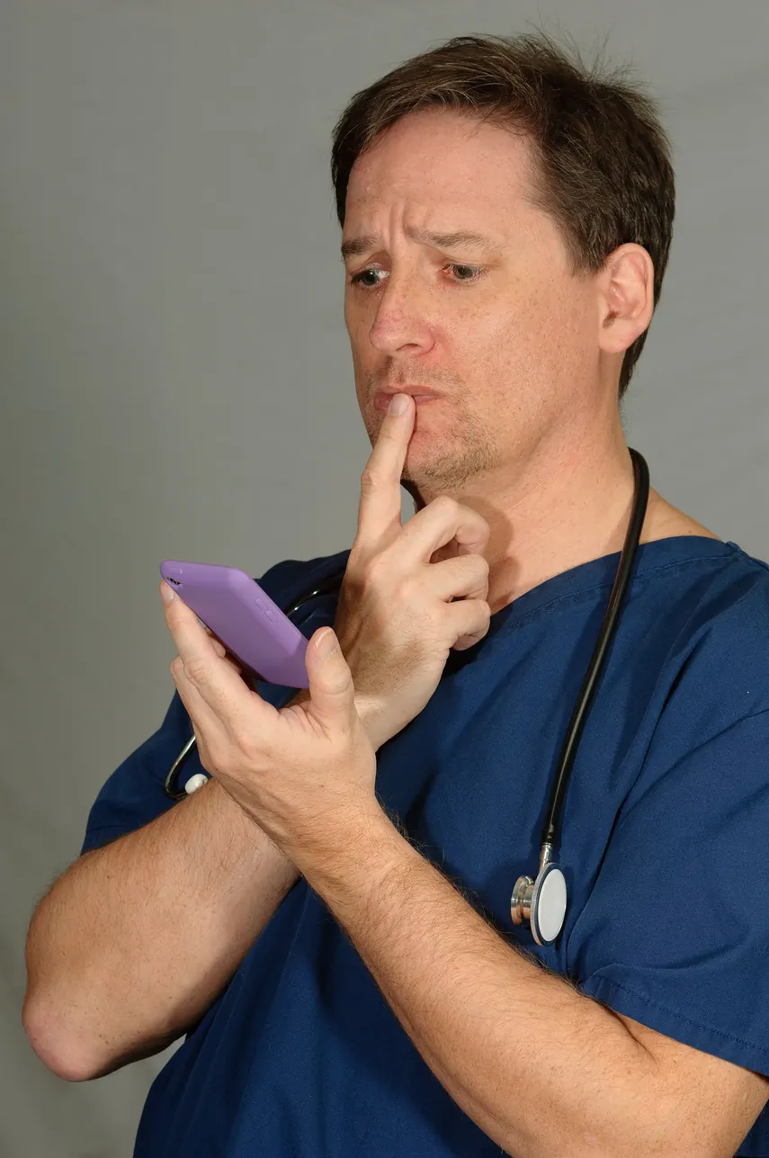 Médico revisando mensajes de WhatsApp sobre un paciente